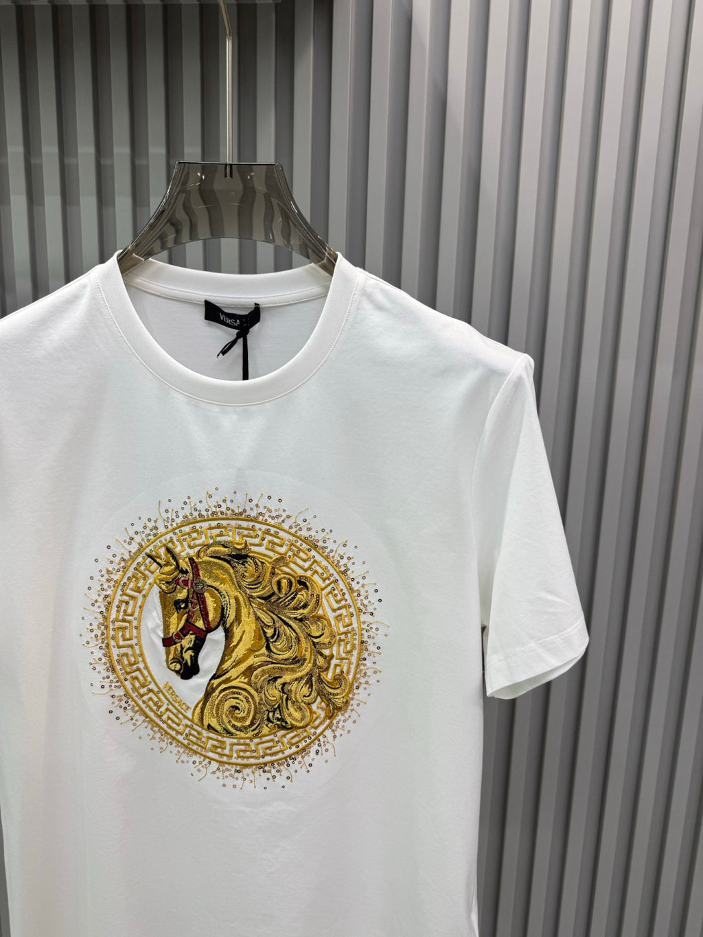 White crew-neck T-shirt featuring gold lion medallion graphic at center front