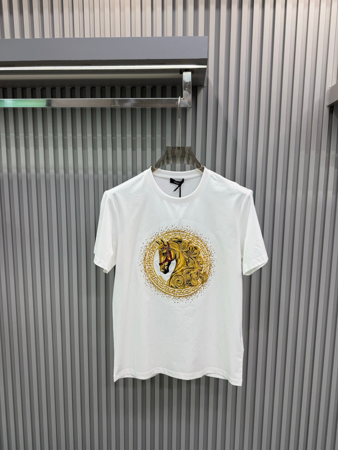 White crew-neck short-sleeve T-shirt with gold lion medallion graphic on chest