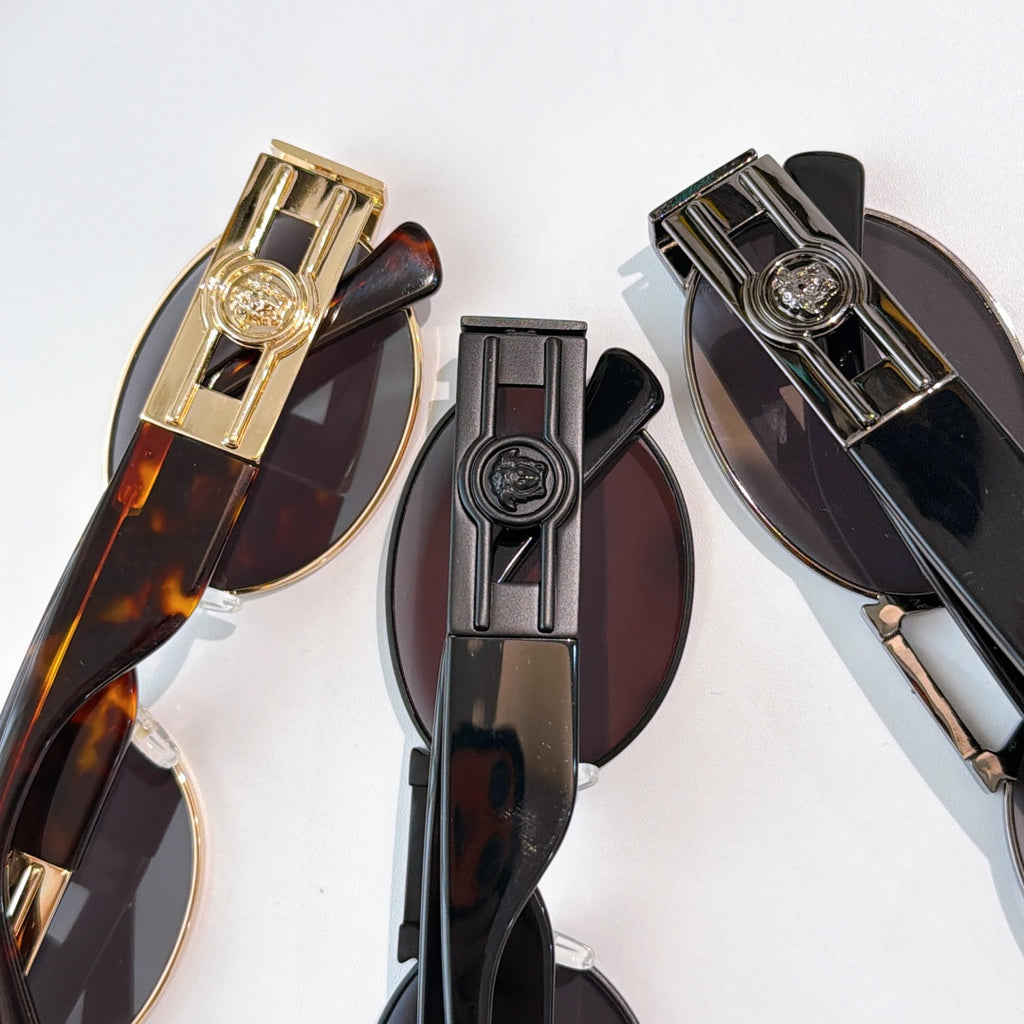 Versace sunglasses, close-up of gold and dark temple hardware with logo medallion