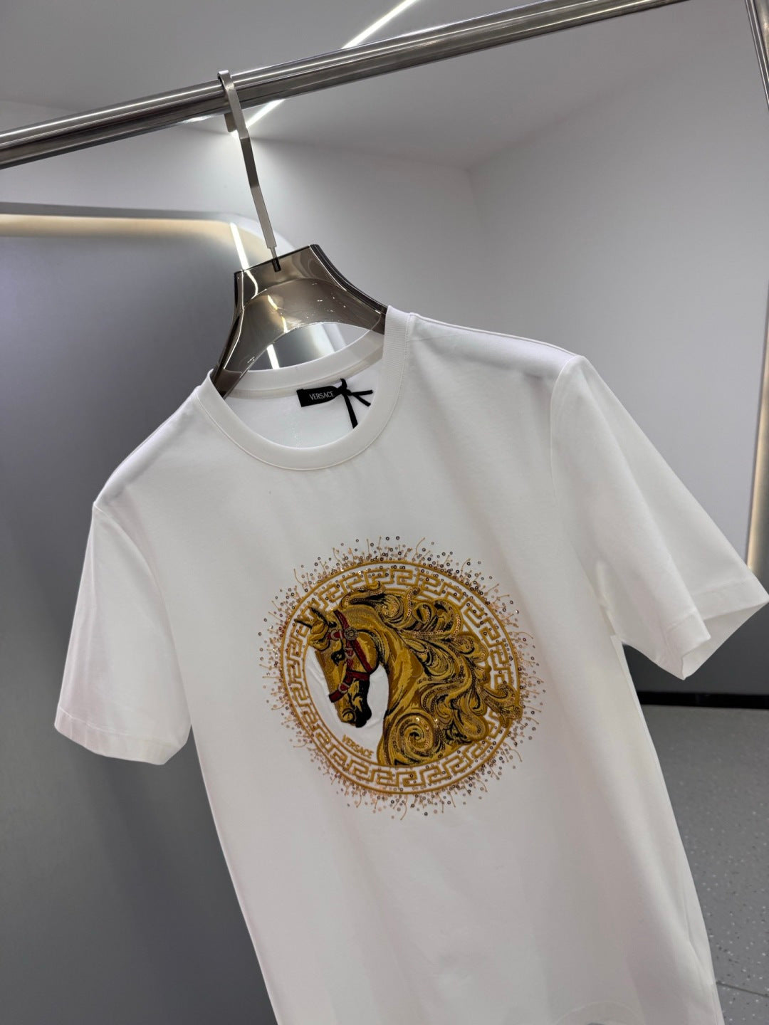 White crew-neck T-shirt with large gold horse emblem graphic on the front