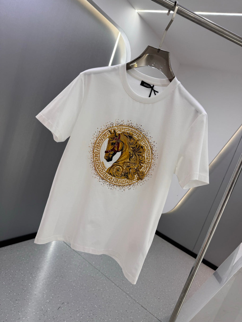 White crew-neck T-shirt featuring a gold horse crest emblem on the chest