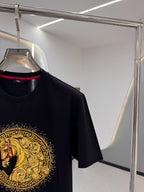 Versace T-shirt sleeve and chest showing gold circular emblem on dark navy
