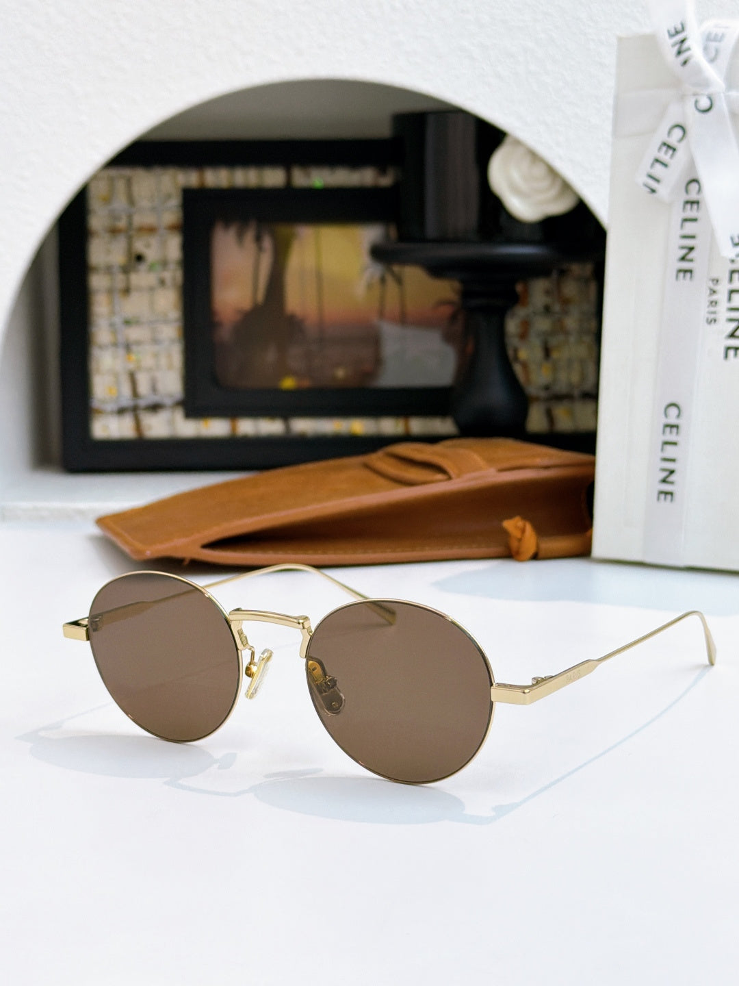 Gold round sunglasses with warm brown lenses and thin metal temples
