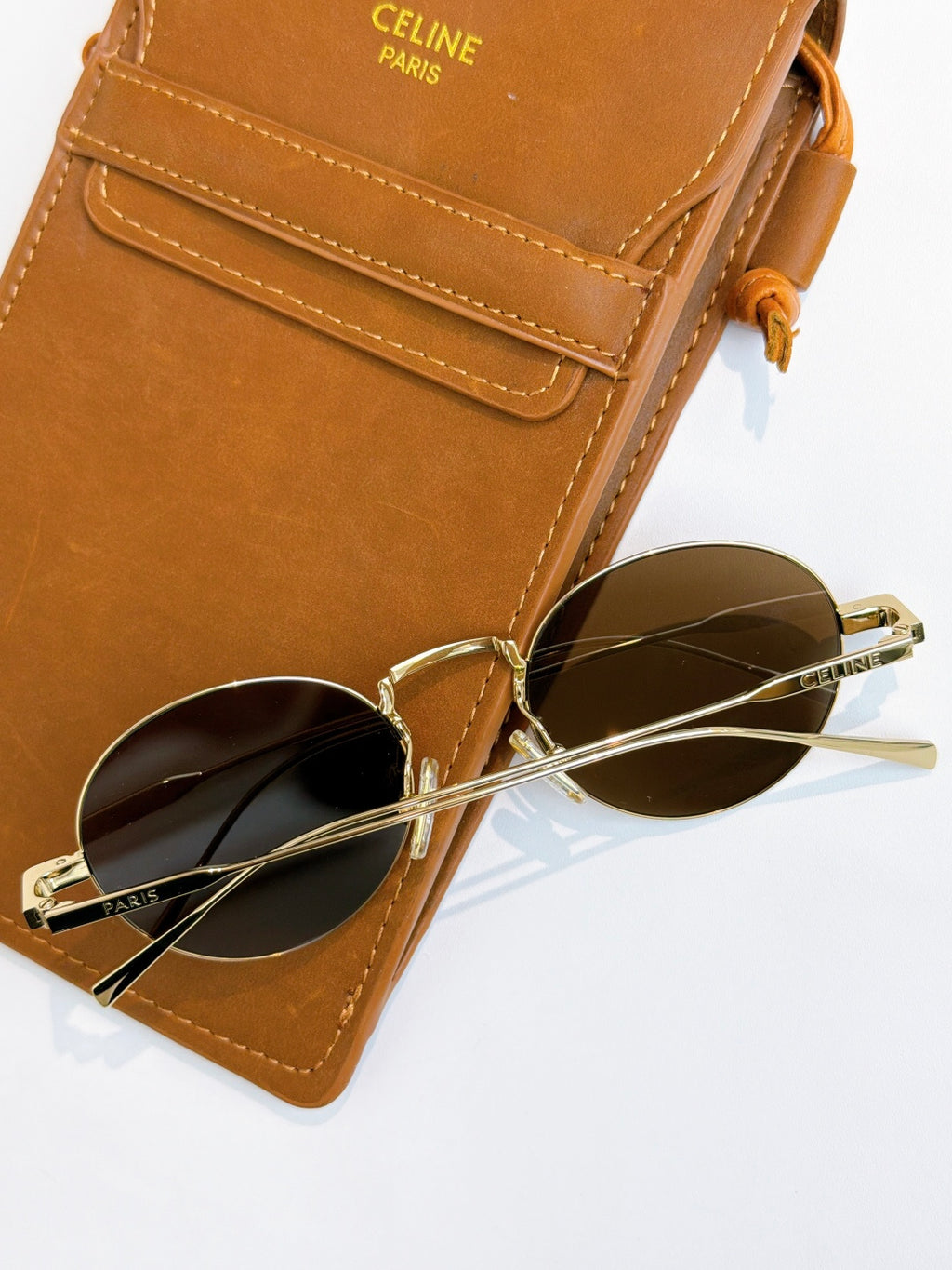 Gold round sunglasses with dark lenses and thin metal temples