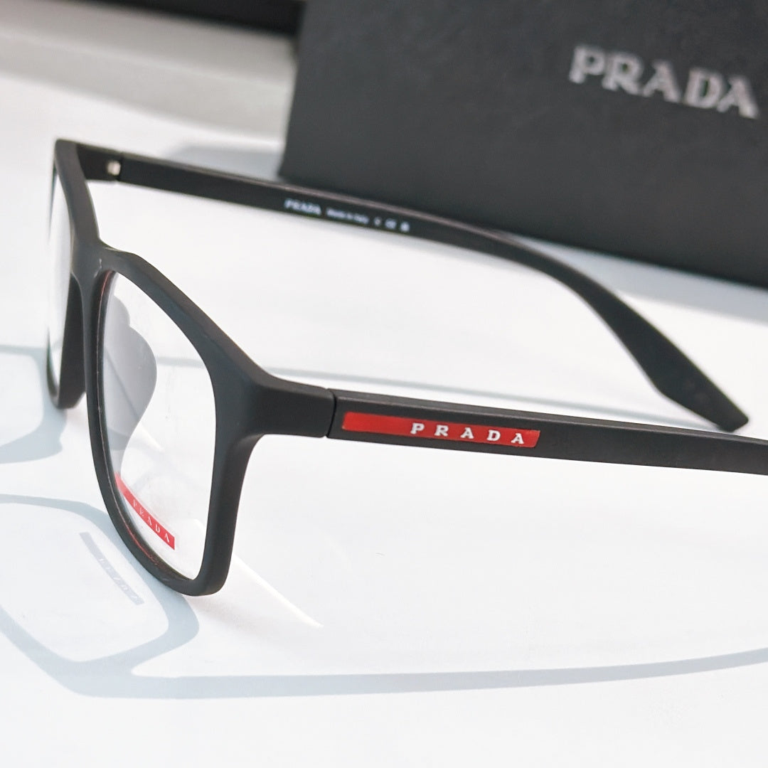 Prada glasses close-up, black frames and PRADA logo bar on temple