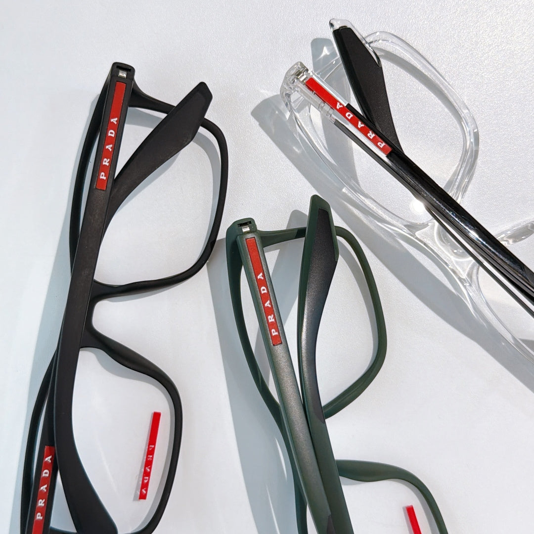 Prada glasses set: black, green, and clear frames with red PRADA logos