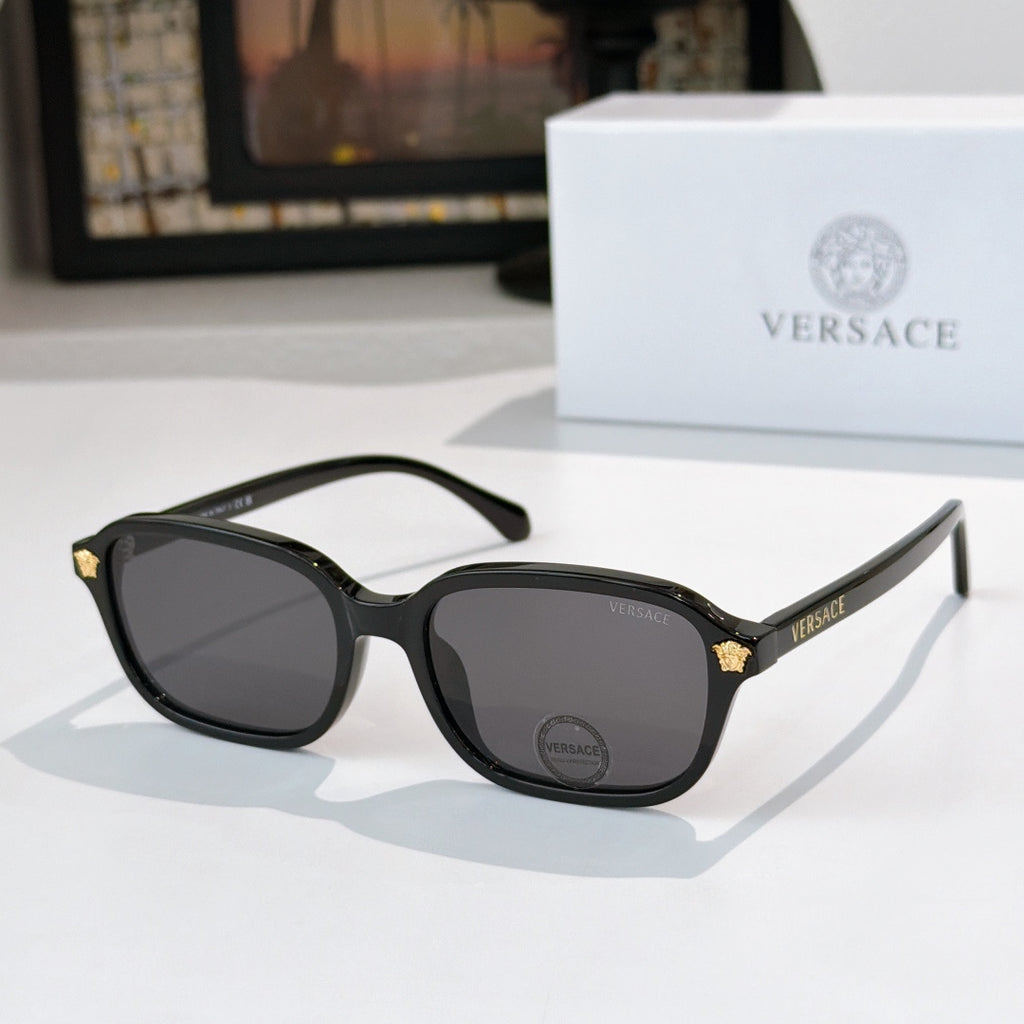 Versace sunglasses with black frame and dark lenses, gold temple accents