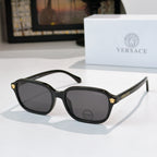 Versace sunglasses with black frame and dark lenses, gold temple accents