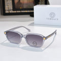 Versace sunglasses with light gray frame and purple tinted lenses, gold temple accents