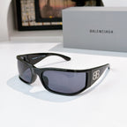 Balenciaga sunglasses with black frame and dark blue tinted lenses.