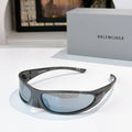 Balenciaga sunglasses with dark gray frames and light blue lenses, curved wrap style.