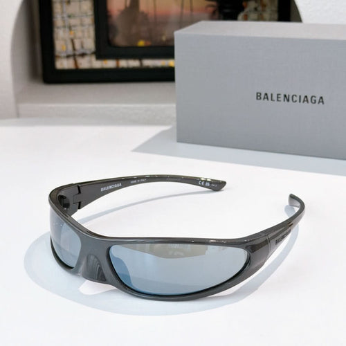 Balenciaga sunglasses with dark gray frames and light blue lenses, curved wrap style.