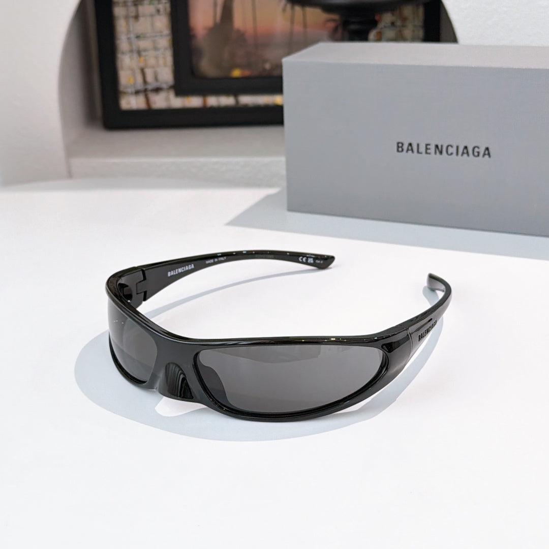 Balenciaga sunglasses with black frames and gray lenses, front view with wrap shape.
