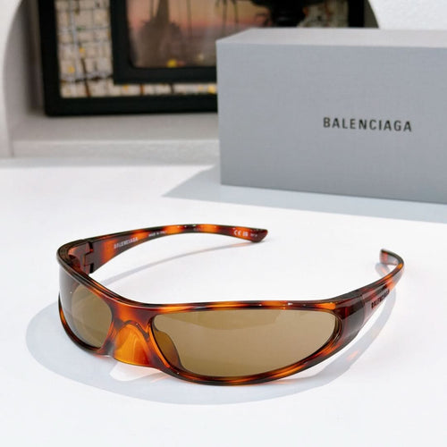 Balenciaga sunglasses with tortoiseshell frames and amber lenses, curved wrap design.