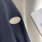 Dark jacket sleeve with embroidered GG-style crest patch