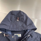Dark hooded jacket with drawstring, embossed emblem on the hood
