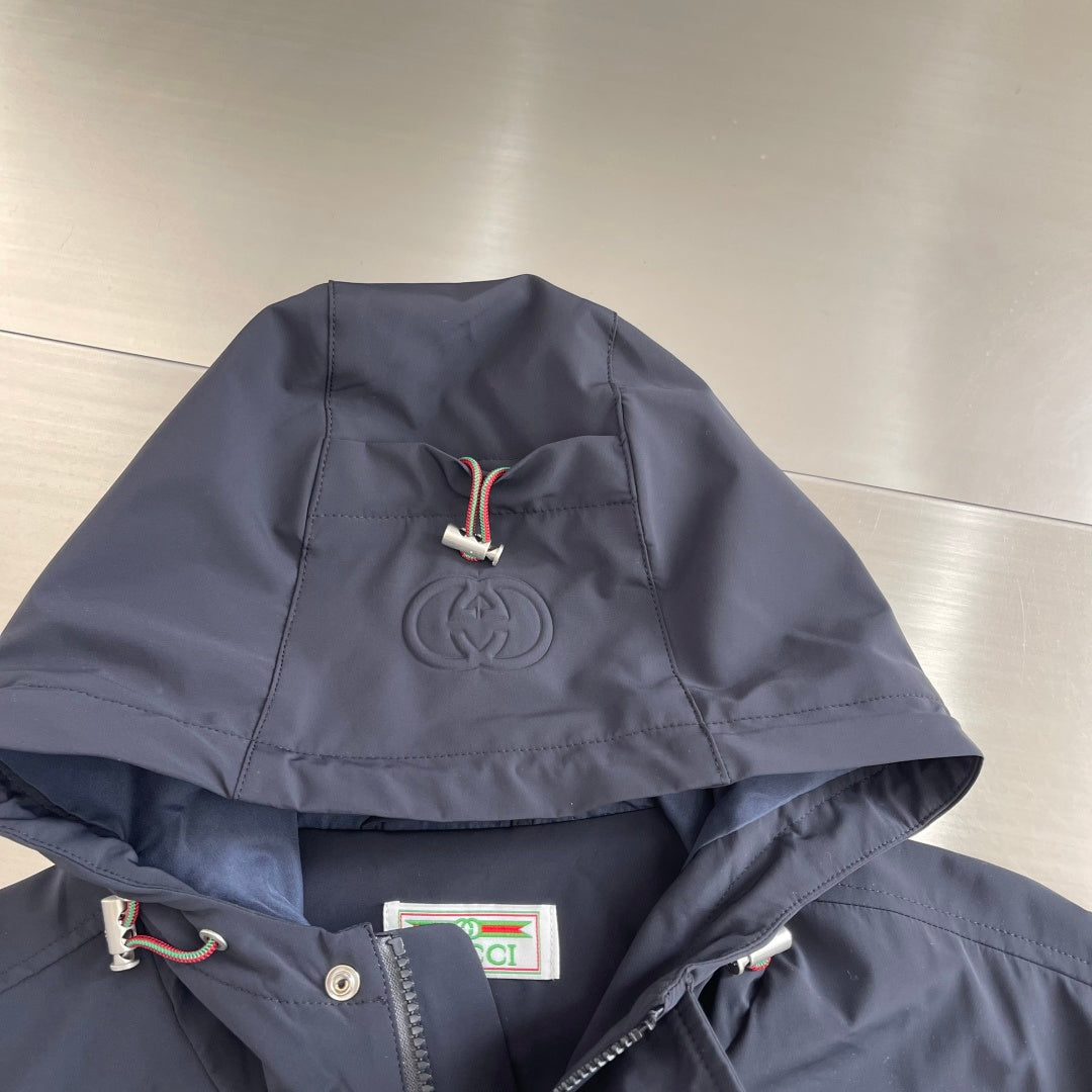 Dark hooded jacket with drawstring, embossed emblem on the hood
