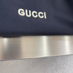 Dark Gucci jacket panel with raised white Gucci logo lettering