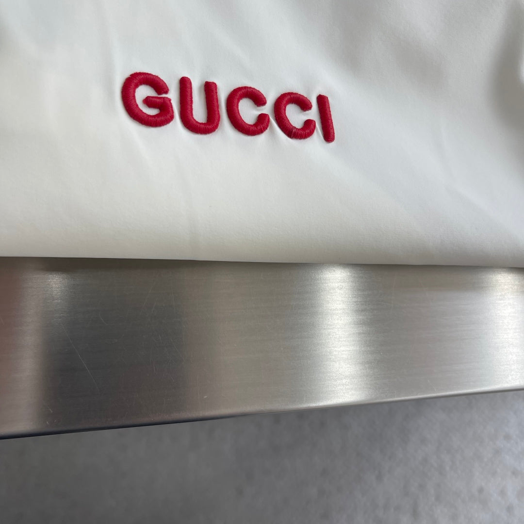 Cream Gucci logo patch with red 'GUCCI' lettering