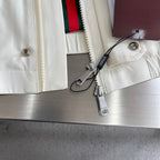 Cream Gucci jacket with zipper, drawcord tags, and snap buttons