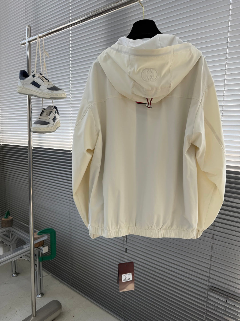 Cream Gucci hooded jacket back view with raised Gucci emblem