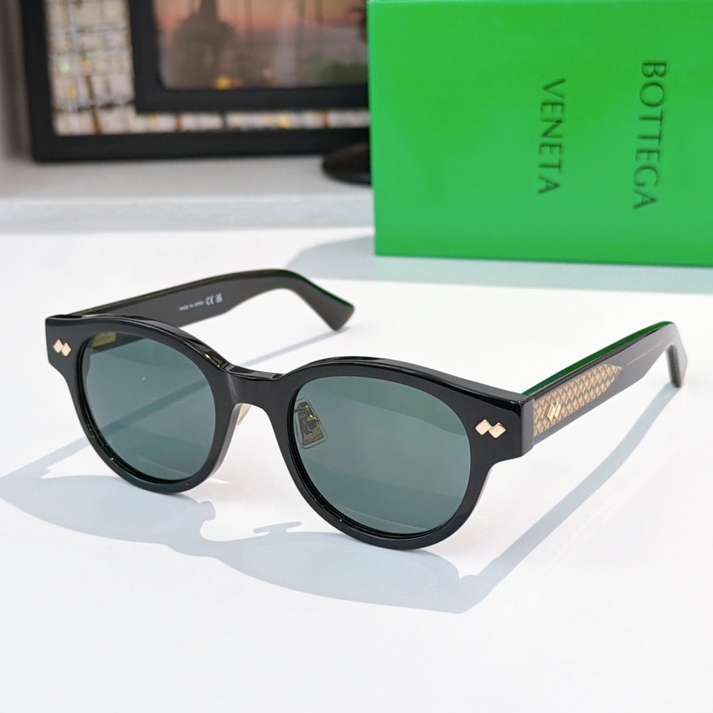 Sunglasses with black frame, blue lenses, and gold-patterned temples