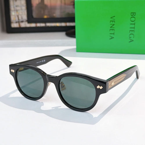 Sunglasses with black frame, blue lenses, and gold-patterned temples