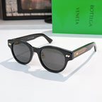 Sunglasses with black frame, gray lenses, and gold-patterned temples