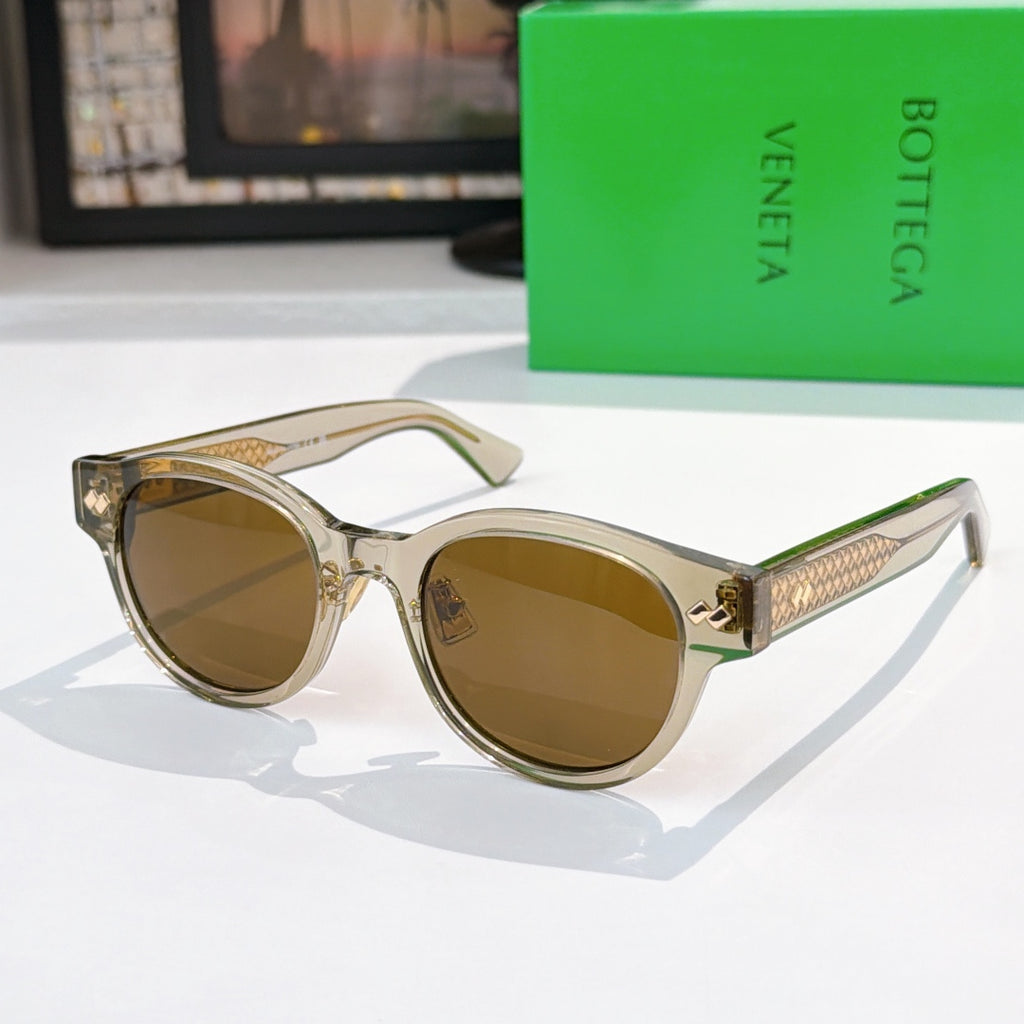 Sunglasses with light frame, brown lenses, and gold-patterned temples