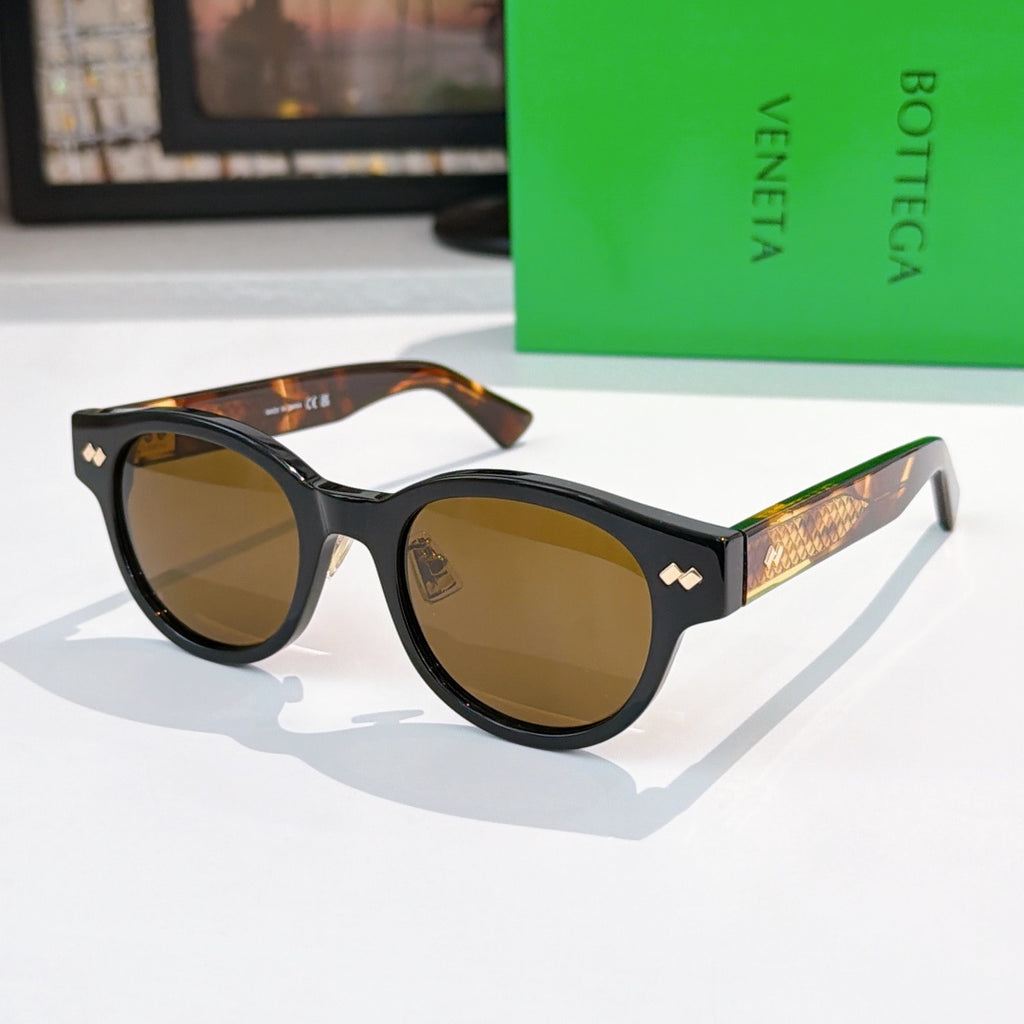 Sunglasses with dark frame, brown lenses, and gold-patterned temples