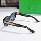 Sunglasses side view with black frame and gold-patterned temples, blue lenses