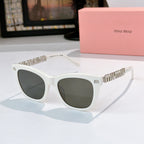 MiuMiu sunglasses with white frames, dark lenses, and gold logo on temple arms
