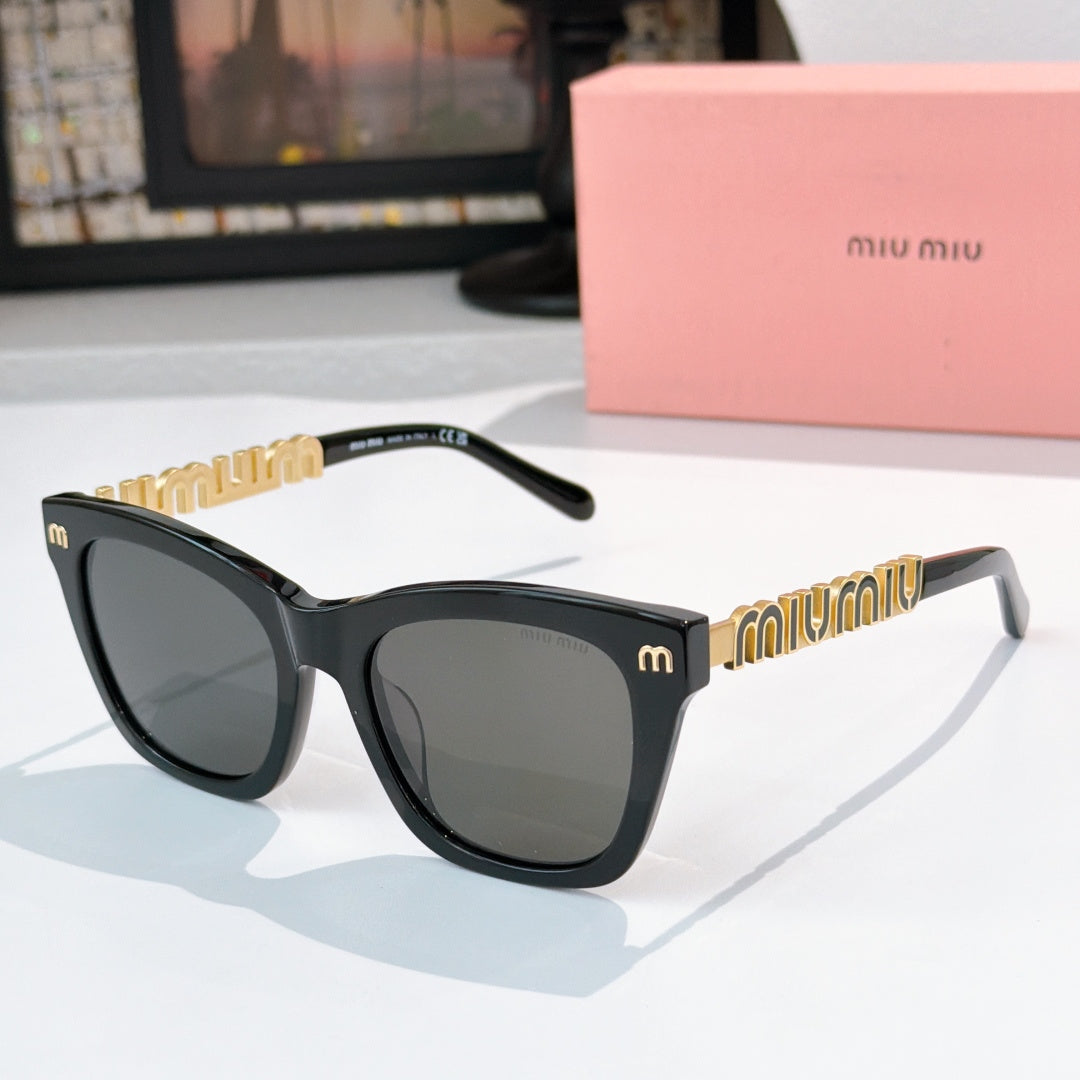 MiuMiu sunglasses with black frames, dark lenses, and gold logo on temple arms
