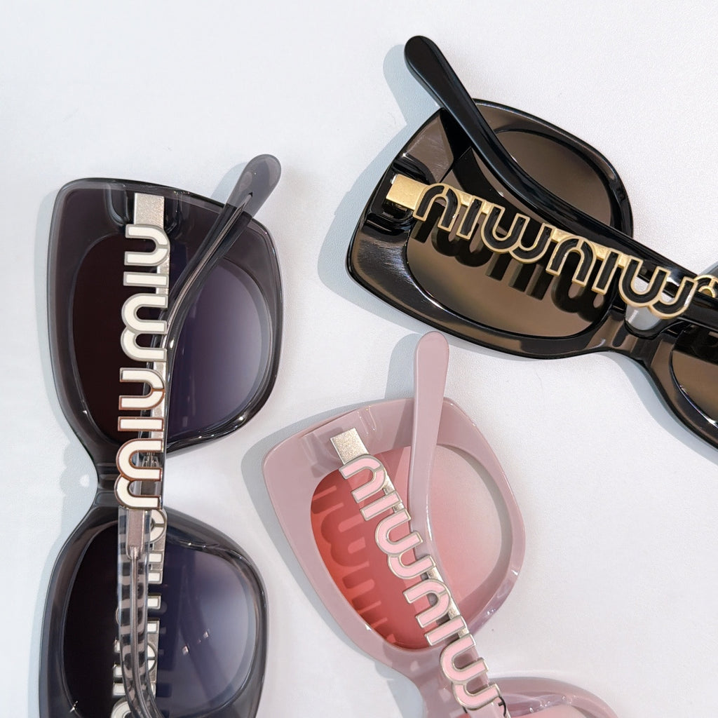 Assorted sunglasses close-up with dark and tinted lenses and gold logo temple details