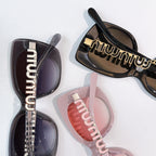 Assorted sunglasses close-up with dark and tinted lenses and gold logo temple details