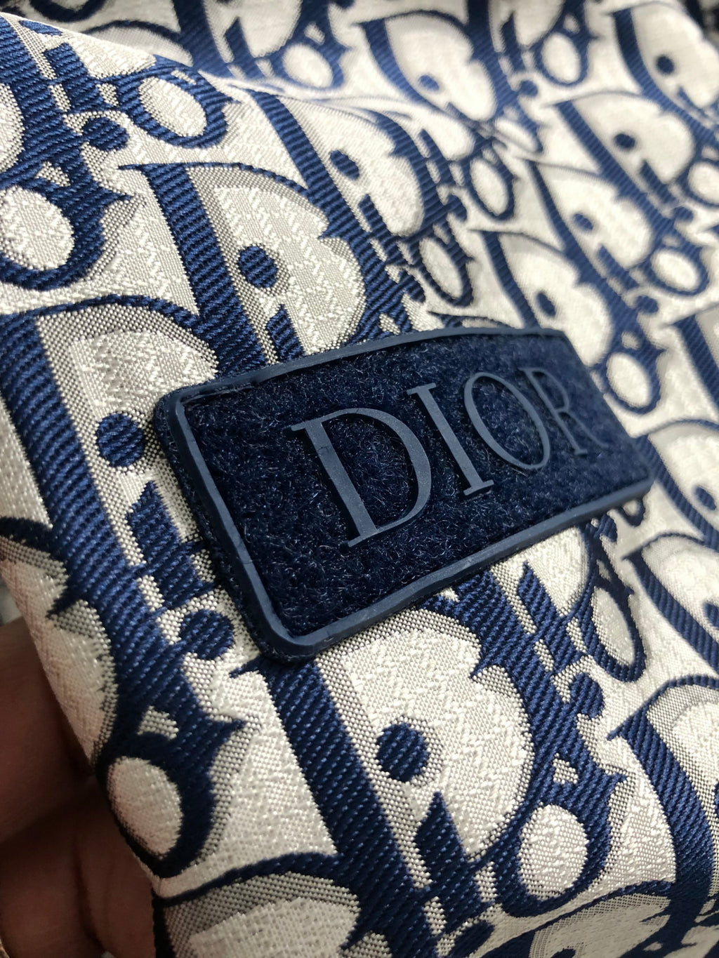 Long Dior logo garment in blue and cream, close-up fabric patch