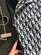 Close-up of Dior monogram jacket zipper and navy-and-white patterned fabric.