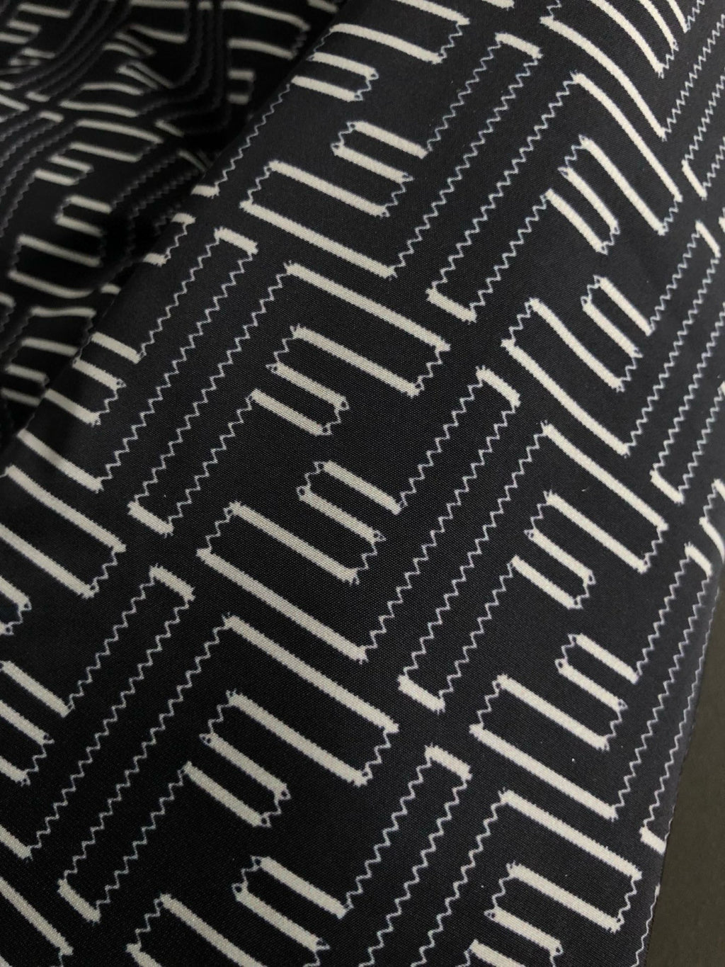Black and off-white geometric logo pattern fabric