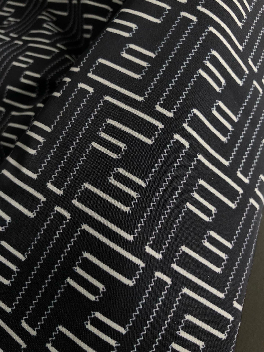 Black and off-white geometric logo pattern fabric