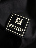 Metal Fendi logo emblem on black fabric patch