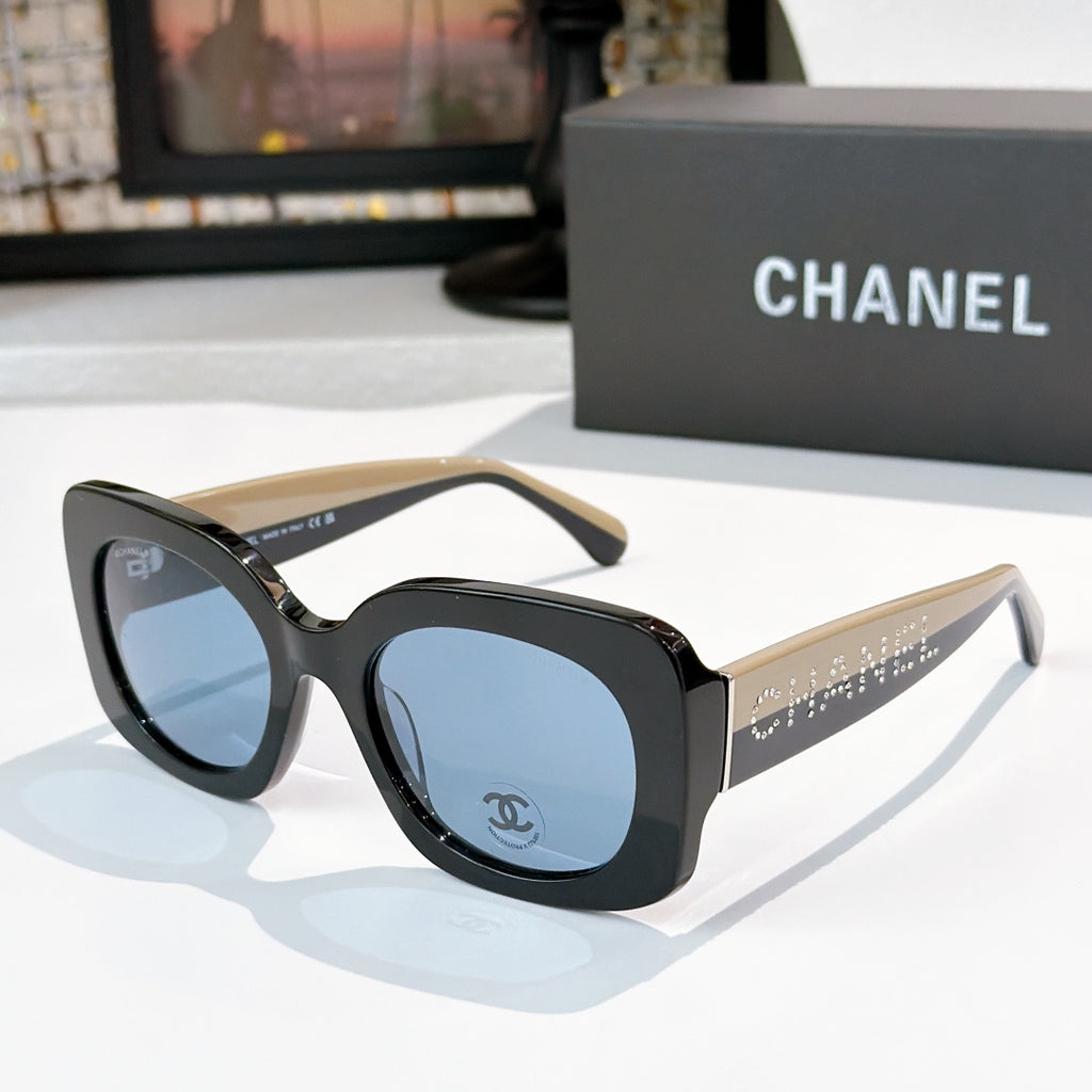 Chanel sunglasses with black frames and blue gradient lenses, studded logo temples