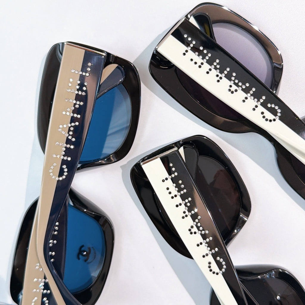 Chanel sunglasses close-up with studded logo temples and tinted lenses in blue and dark tones