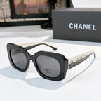 Chanel sunglasses with black frames and gray gradient lenses, studded logo temples