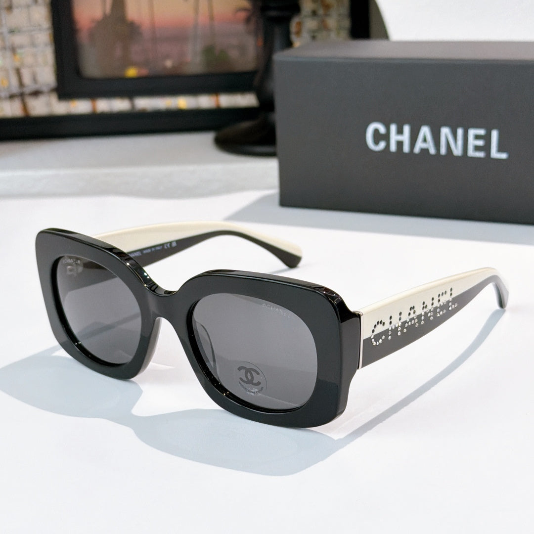 Chanel sunglasses with black frames and gray gradient lenses, studded logo temples