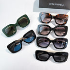 Chanel sunglasses assortment on display: green, blue, tortoiseshell, and black styles
