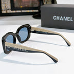 Chanel sunglasses with black frames, blue lenses, and tan temple arms with studded logo