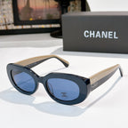 Chanel sunglasses with dark blue lenses, black frames, cream temples and logo detail