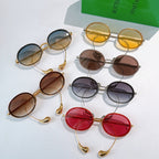 Assorted oval sunglasses with various tinted lenses and gold- and silver-tone frames.
