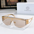 Gold-tone sunglasses with beige-tinted lenses and decorative temple emblem