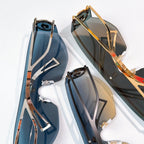 Pair of gold-trimmed sunglasses with dark blue lenses, angled view